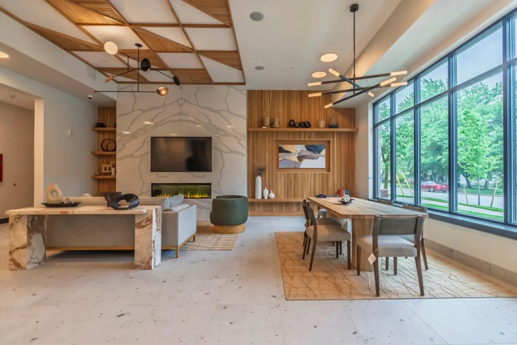 Packard Row clubhouse with marble fireplace, custom wood ceiling treatment, and floor-to-ceiling windows looking out to greenspace